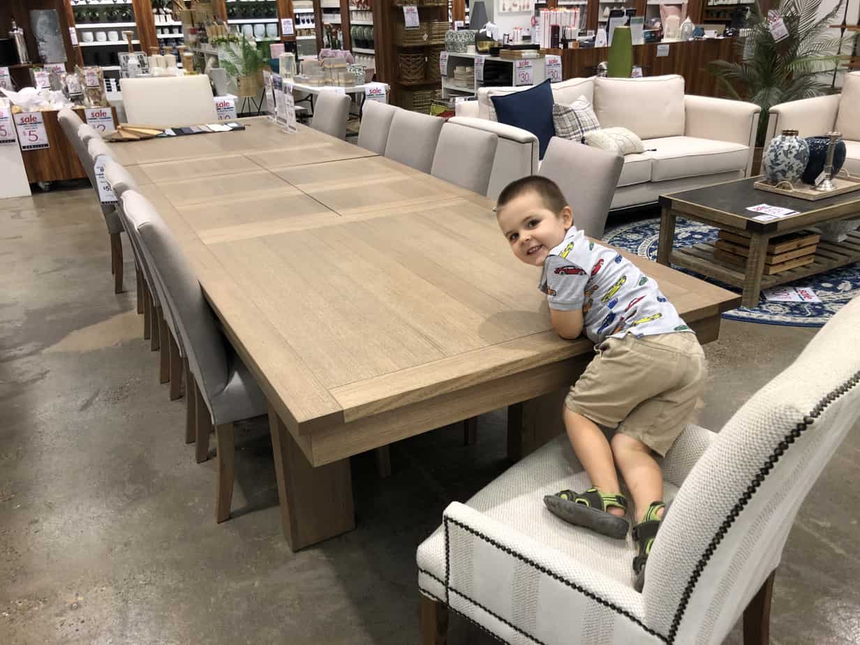 3 year old counting chairs at table