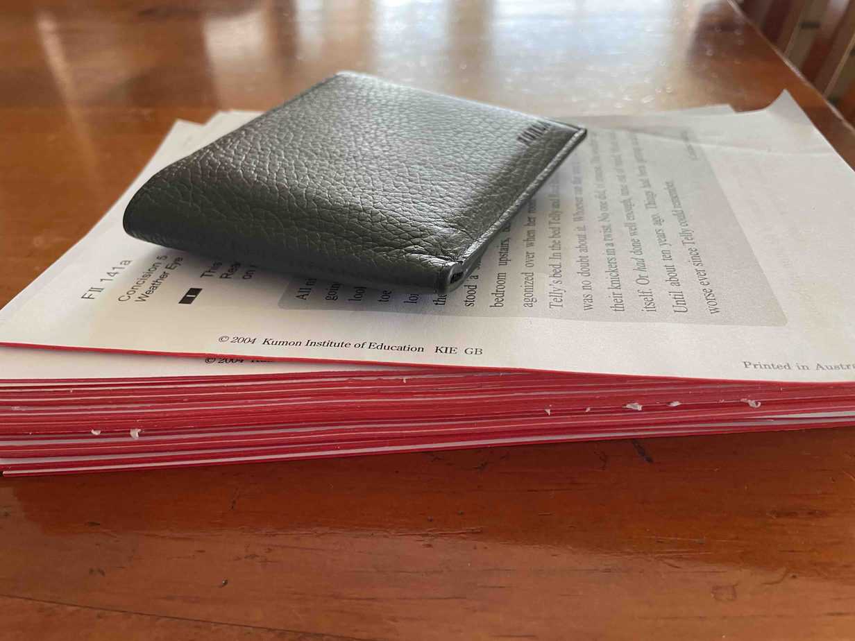 Wallet on top of Kumon reading booklets